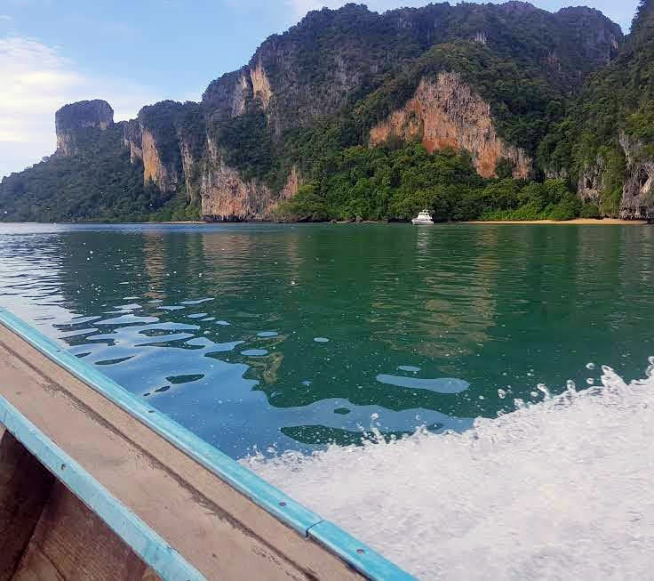 Traditional Thai longtail boat cruising clear water